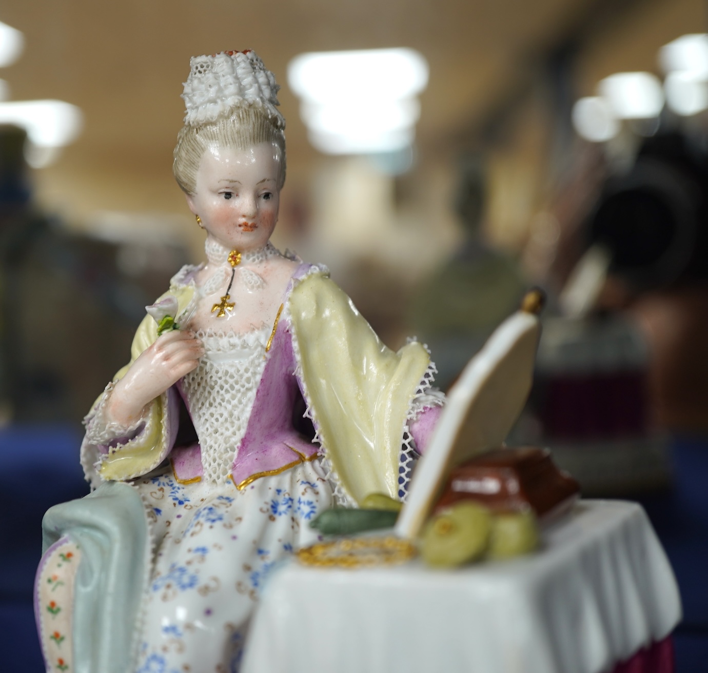 A late 19th century Meissen figure of Sight, from the Senses, a seated lady at her dressing table, crossed swords mark and incised E3 mark to base, 14cm high